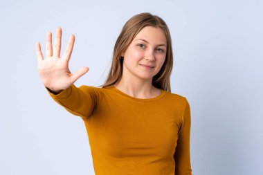 Genç Ukraynalı kız mavi arka planda izole edilmiş, parmaklarıyla beşi sayıyor.