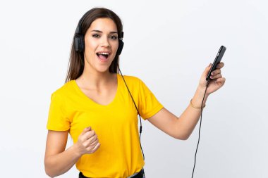 Beyaz arka planda izole edilmiş beyaz bir kadın müzik dinliyor ve gitar hareketi yapıyor.