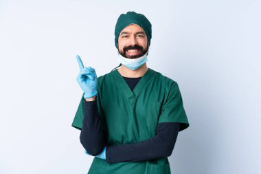 Yeşil üniformalı bir cerrah, izole edilmiş arka planda mutlu ve dik duruyor.