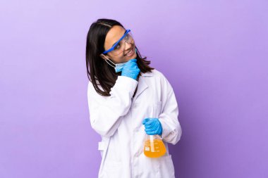 Koronavirüs hastalığını tedavi eden bir aşıyı araştıran bilim kadını gülümserken yukarı bakıyor.