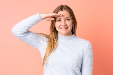 Genç Ukraynalı kız pembe arka planda izole edilmiş, mutlu bir ifadeyle selamlanıyor.