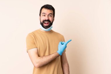 Koronavirüsten sakallı, maskeli ve eldivenli beyaz bir adam.