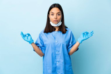 Zen pozunda mavi arka plan üzerinde cerrah kadın