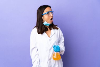 Koronavirüs hastalığını tedavi eden bir aşıyı araştıran bilim kadını şaşırmış bir ifadeyle yukarı bakıyor.