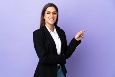 Mor arka planda izole edilmiş bir iş kadını işaret ediyor.