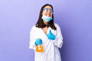 Koronavirüs hastalığını tedavi eden bir aşıyı araştıran bilim adamı kadın baş parmak işareti yapıyor.