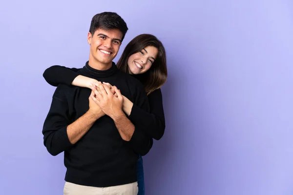 Casal Jovem Sobre Isolado Fundo Roxo Rindo Abraçando — Fotografia de Stock