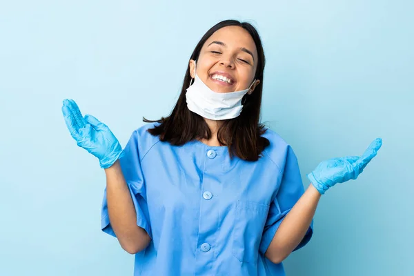 在孤立的蓝色背景上的外科医生女人笑得很开心 — 图库照片