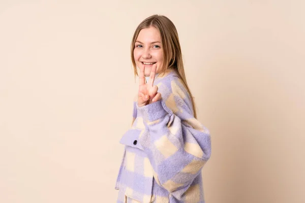 Nastoletnia Ukraińska Dziewczyna Odizolowana Beżowym Tle Uśmiecha Się Pokazuje Znak — Zdjęcie stockowe