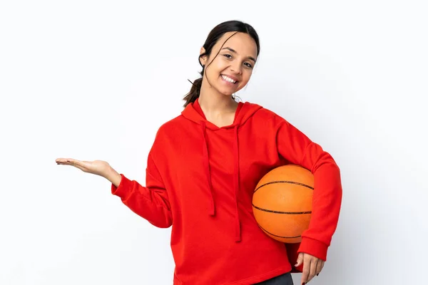 年轻女子在孤零零的白色背景上打篮球 手握想象中的复制空间插入广告 — 图库照片