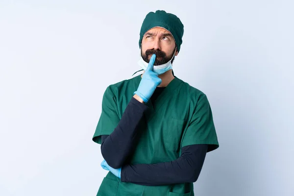 Cirurgião Homem Uniforme Verde Sobre Fundo Isolado Com Dúvidas Olhar — Fotografia de Stock