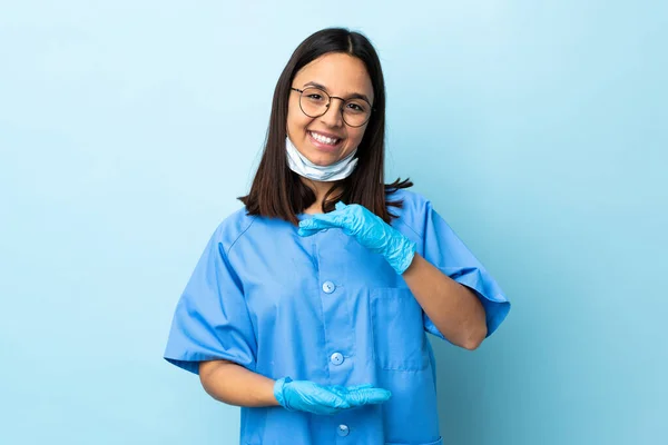 Chirurg Kobieta Nad Odizolowanym Niebieskim Tle Trzymając Copyspace Wyobraźni Dłoni — Zdjęcie stockowe