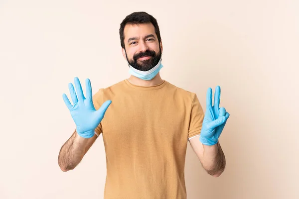 一个白种人 留着胡子 戴着面具 戴着手套 在孤立的背景上保护自己不受考拉威斯的伤害 他有7个手指 — 图库照片
