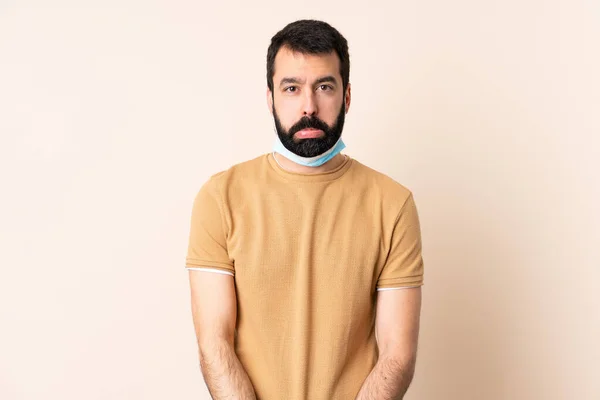 髭を生やしてコロナウイルスから身を守る白人男性 マスクと手袋で隔離された背景に悲しい表情 — ストック写真