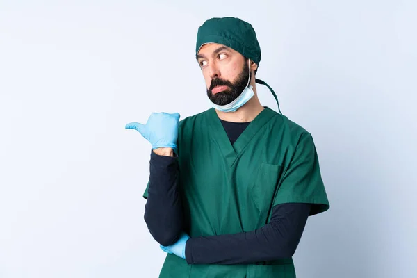 Cirurgião Homem Uniforme Verde Sobre Fundo Isolado Infeliz Apontando Para — Fotografia de Stock