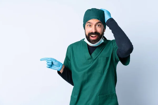 Cirurgião Homem Uniforme Verde Sobre Fundo Isolado Surpreendido Apontando Dedo — Fotografia de Stock