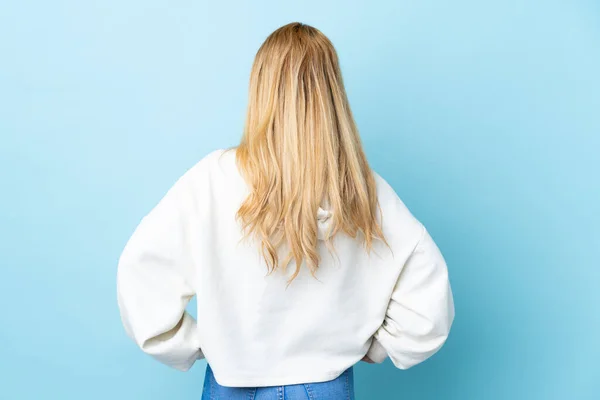 Молодая Уругвайская Блондинка Изолированном Синем Фоне Задней Позиции — стоковое фото