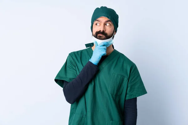Cirurgião Homem Uniforme Verde Sobre Fundo Isolado Com Dúvidas Com — Fotografia de Stock