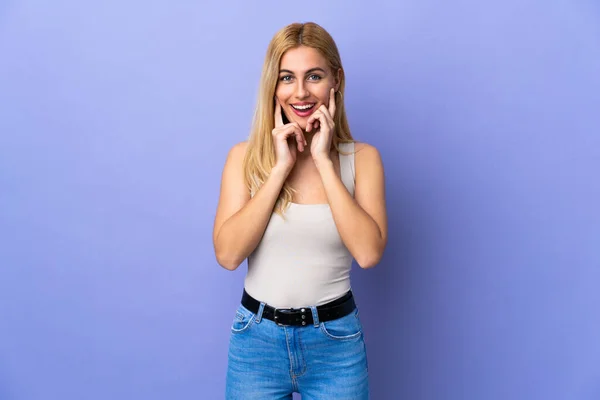 Ung Uruguayansk Blond Kvinna Över Isolerad Bakgrund Ler Med Ett — Stockfoto