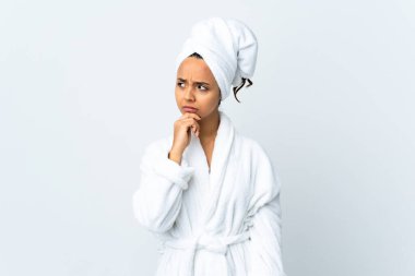 Bornozlu genç bir kadın, izole edilmiş beyaz bir geçmişi var. Şüpheleri var ve kafası karışmış bir yüz ifadesi var.