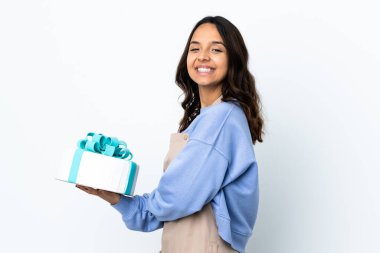 Pasta şefi izole edilmiş beyaz arka planda büyük bir pasta tutuyor. Kolları bağlı ve ileriye bakıyor.