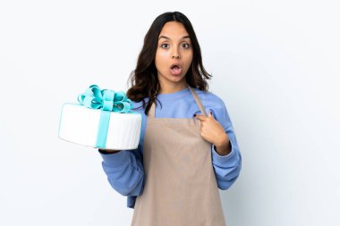 Pasta şefi kendini gösteren izole edilmiş beyaz arka plan üzerinde büyük bir pasta tutuyor.