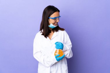 Koronavirüs hastalığını tedavi eden bir aşıyı araştıran bilim kadını yan tarafa bakıp gülümsüyor.