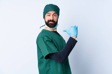 Yeşil üniformalı bir cerrah soyutlanmış arka planda gururlu ve kendini beğenmiş.