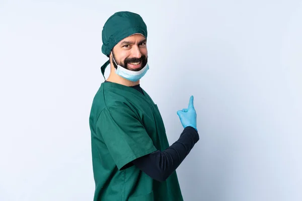 Cirurgião Homem Uniforme Verde Sobre Fundo Isolado Apontando Para Trás — Fotografia de Stock