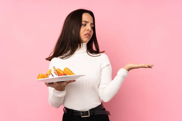 Young Brunette Woman Holding Waffles Isolated Pink Background Holding Copyspace — Stock Photo, Image