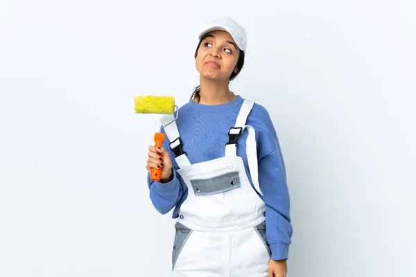 Painter woman over isolated white background having doubts while looking up