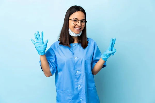 孤立的蓝色背景上的外科医生妇女用手指数着7 — 图库照片