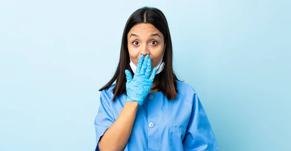 Mujer Cirujana Sobre Fondo Azul Aislado Cubriendo Boca Con Mano —  Fotos de Stock