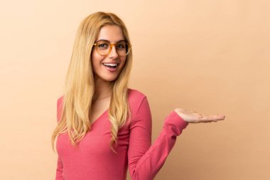 Genç Uruguaylı sarışın kadın izole bir arka planda gülümserken bir fikir sunuyor.