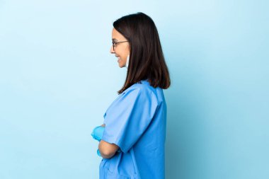 Yan pozisyonda mavi arka plan üzerinde cerrah kadın