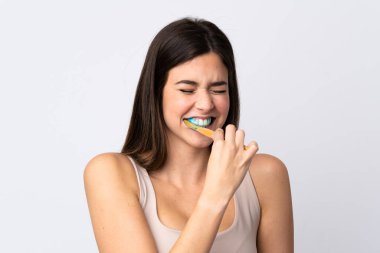 Genç Brezilyalı kız dişlerini izole edilmiş beyaz arka planda fırçalıyor.