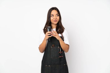 Genç kuaför kadın beyaz arka planda bir şeyler planlıyor.