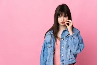 Pembe arka planda izole edilmiş genç Ukraynalı kadın sessizlik işareti gösteriyor.