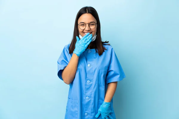 孤立的蓝色背景上的外科医生女人快乐地微笑着用手捂住嘴 — 图库照片