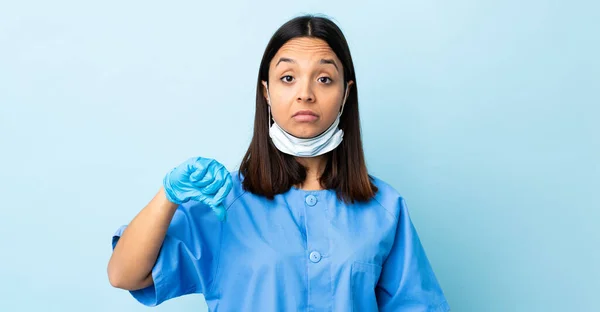 Chirurg Kobieta Nad Odizolowanym Niebieskim Tle Pokazuje Kciuk Dół Negatywnym — Zdjęcie stockowe