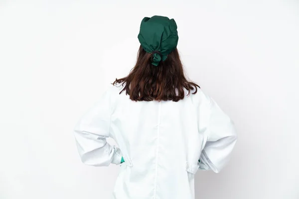背部位置の白い背景に隔離された緑の制服を着た外科医の女性 — ストック写真