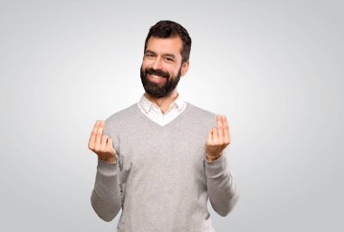 Yakışıklı adam, izole edilmiş gri arka planda para yapıyor.