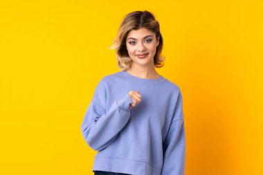 Sarı arka planda yalıtılmış genç Rus kadın, şaşırmış yüz ifadesi ile