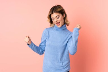 Pembe arka planda izole edilmiş genç Rus kadın zaferi kutluyor.