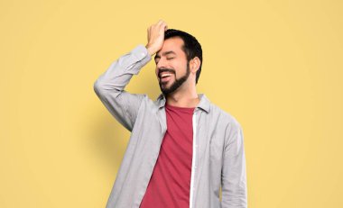 Sakallı yakışıklı bir adam bir şey fark etti ve çözümü izole edilmiş sarı arka planda arıyor.