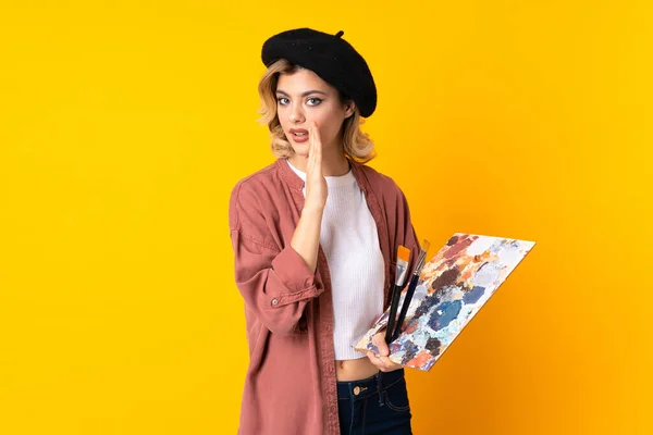 Young Artist Girl Holding Palette Isolated Yellow Background Whispering Something — Stock Photo, Image