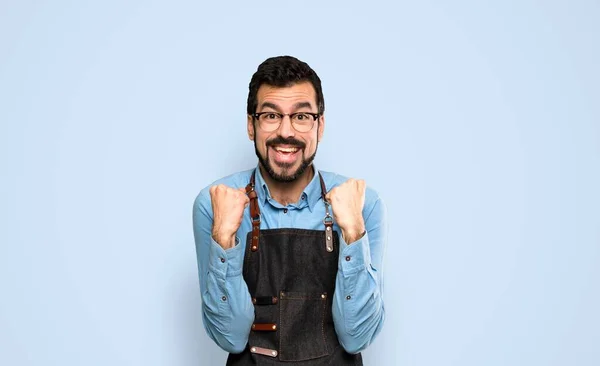 Mann Mit Schürze Feiert Sieg Vor Blauem Hintergrund — Stockfoto