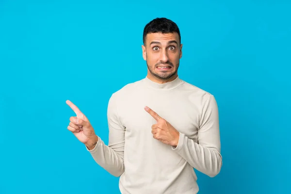 Joven Sobre Fondo Azul Aislado Asustado Señalando Hacia Lado — Foto de Stock