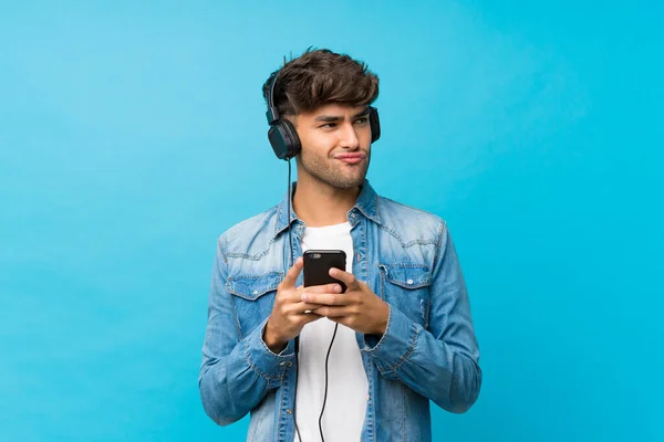 Joven Hombre Guapo Sobre Fondo Azul Aislado Usando Móvil Con — Foto de Stock