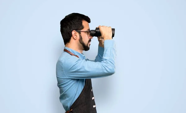 Man Apron Binoculars Isolated Blue Background — Stock Photo, Image